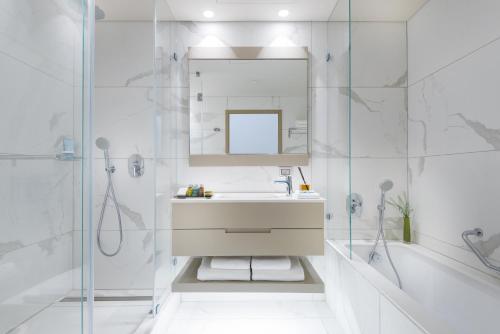a white bathroom with a sink and a mirror at U Boutique Kinneret by the Sea of Galilee in Tiberias