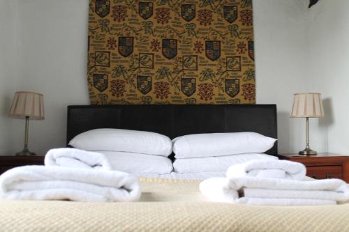 a room with a bed with towels on it at Old Court Hotel & Apartments in Symonds Yat
