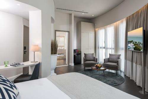 a bedroom with a bed and a desk and chairs at U Boutique Kinneret by the Sea of Galilee in Tiberias