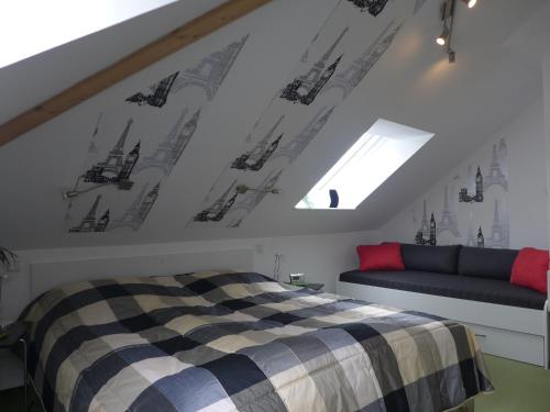 Schlafzimmer im Dachgeschoss mit einem Bett und einem Sofa in der Unterkunft Fewo Schimpf Pirna in Pirna