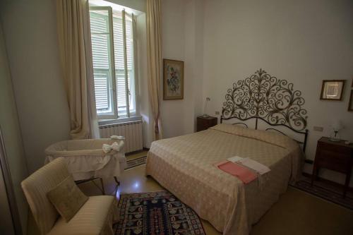 a bedroom with a bed and a chair and a window at Villa Daura in Riccò del Golfo di Spezia