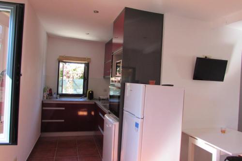 a kitchen with a white refrigerator and a window at Casas da Nazare in Ponte de Lima