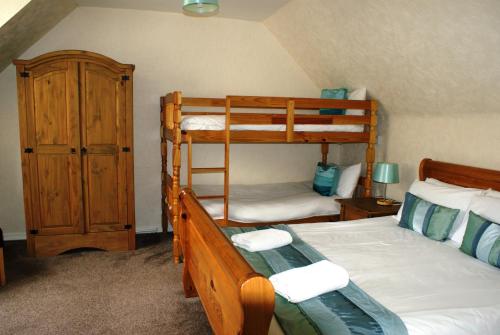 a bedroom with two bunk beds and a closet at Royal Lodge in Symonds Yat