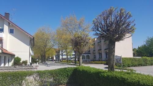 a large white building with trees in front of it at Kurhotel Anders in Bad Füssing
