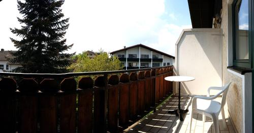 a patio with a table and a chair on a fence at Kurhotel Anders in Bad Füssing