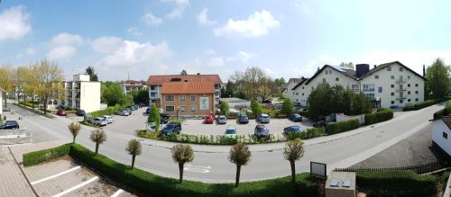 a street in a town with cars and houses at Kurhotel Anders in Bad Füssing