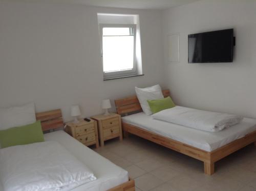 a room with two beds and a flat screen tv at Boardinghouse Casita Amann in Friedrichshafen