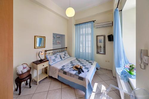 1 dormitorio con cama, escritorio y ventana en Antouanetta Apartments, en Ermoupoli