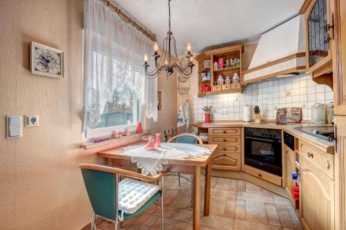 a kitchen with a table and chairs and a chandelier at Ferienhaus Matthies in Kolpinsee
