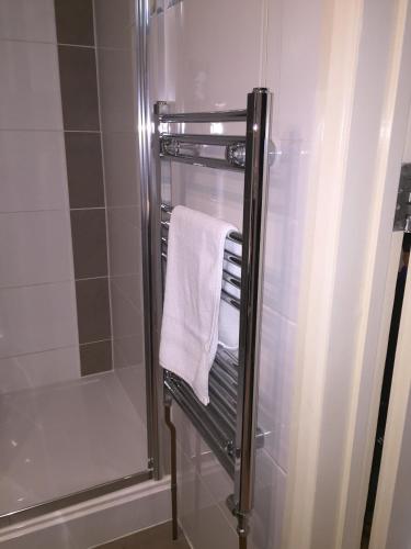 a bathroom with a shower and a towel at Lyall Apartment Hotel in London