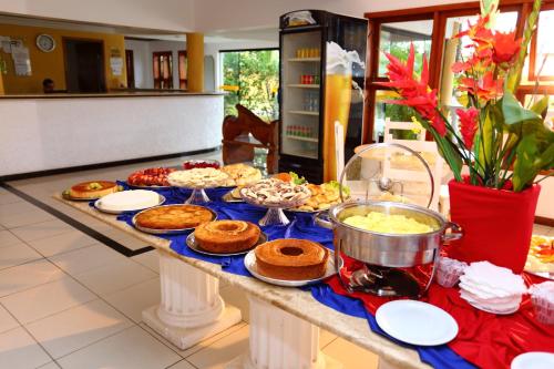 un buffet de comida en una mesa en una cocina en Benko´s Praia Hotel, en Porto Seguro
