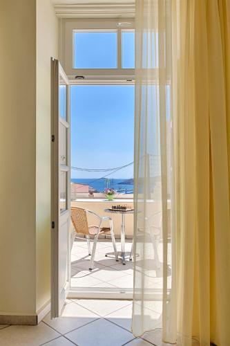 a room with a door open to a patio with a table at Antouanetta Apartments in Ermoupoli