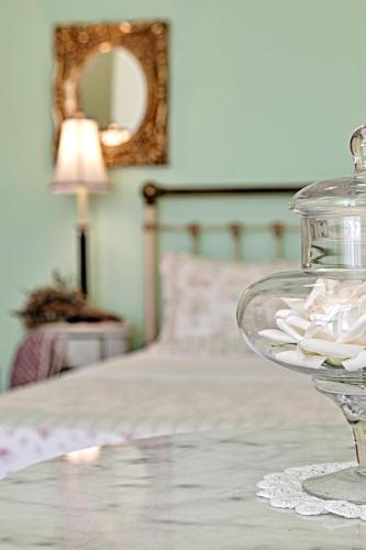 a glass bowl on a table next to a bed at Antouanetta Apartments in Ermoupoli