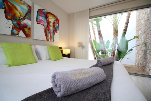 - une chambre avec un lit et des serviettes dans l'établissement Villa Bellissima, à Bahía de Sant Antoni