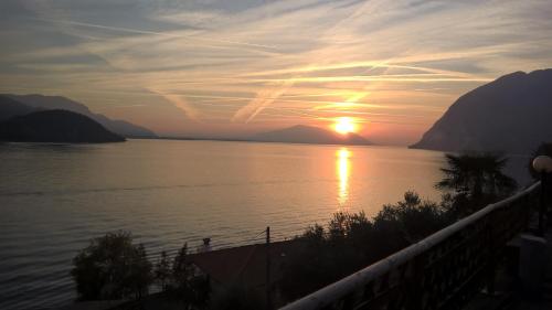 a sunset over a body of water with mountains at Residenza Borgo Antico in Monte Isola