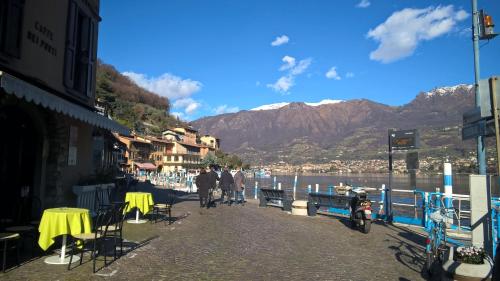 a group of people walking down a sidewalk near the water at Residenza Borgo Antico in Monte Isola