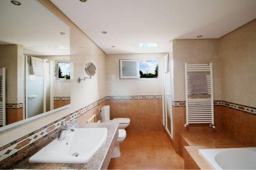 a bathroom with two sinks and a toilet at Villa Bellissima in San Antonio Bay