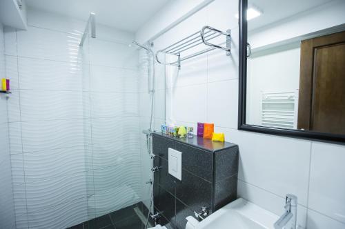 a bathroom with a glass shower and a sink at Heartland City B&B in Tuzla