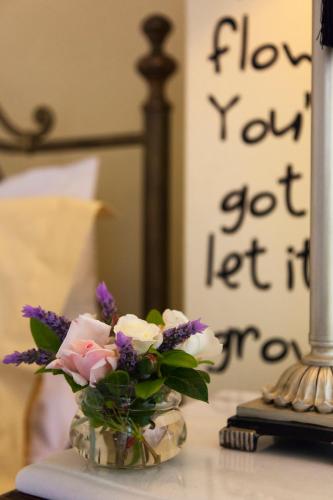 a vase of flowers sitting on a table with a mirror at Antouanetta Apartments in Ermoupoli
