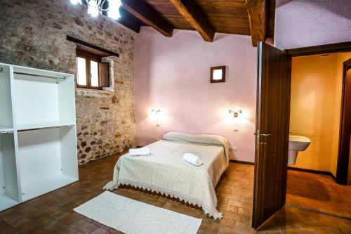 a bedroom with a bed and a toilet in a room at Le Aie Di Postignano in Sellano