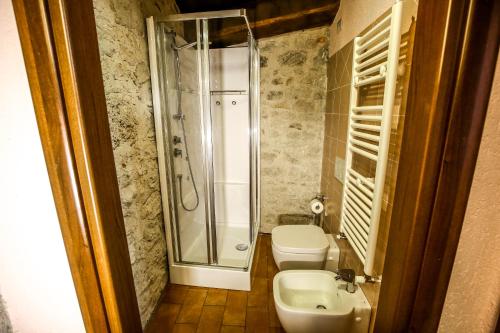 a bathroom with a shower and a toilet and a sink at Le Aie Di Postignano in Sellano