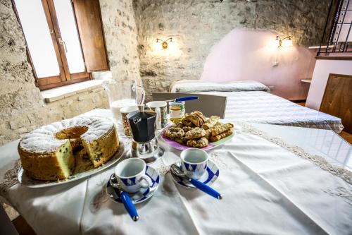 a table with a cake and a plate of cookies at Le Aie Di Postignano in Sellano