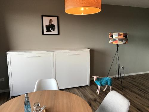 a dining room with a table and a figurine of a dog at Das Hotel Ostseeblick in Lütjenburg