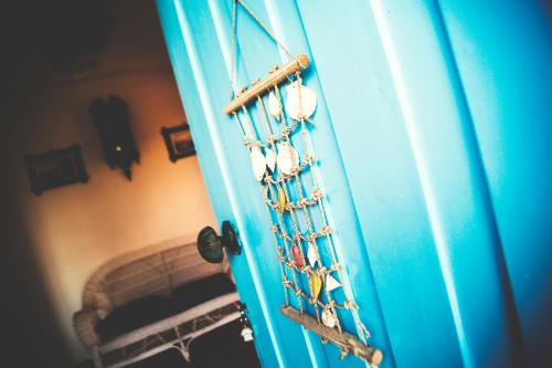 a blue door with a chain with birds on it at Villa Moby Dick in Mitikas