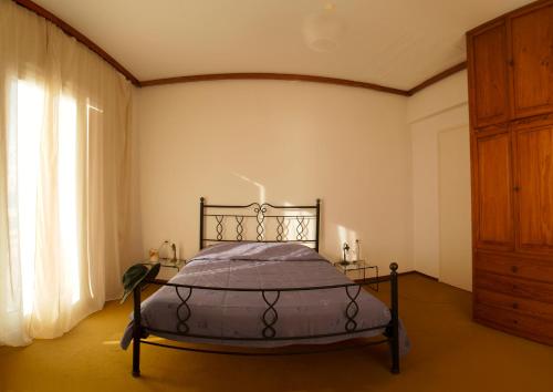 a bedroom with a bed and a large window at Villa Moby Dick in Mitikas