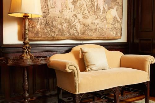 a chair and a lamp in a room with a painting at The Inn at 97 Winder in Detroit