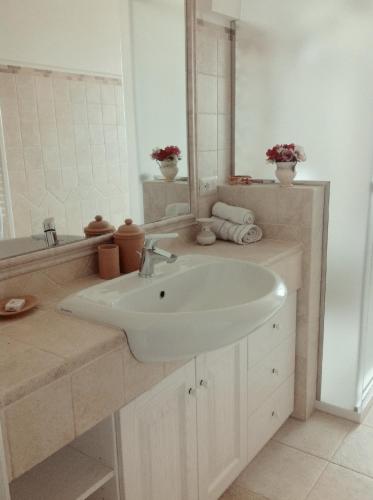 a white bathroom with a sink and a mirror at I Trulli del Mulino in Locorotondo