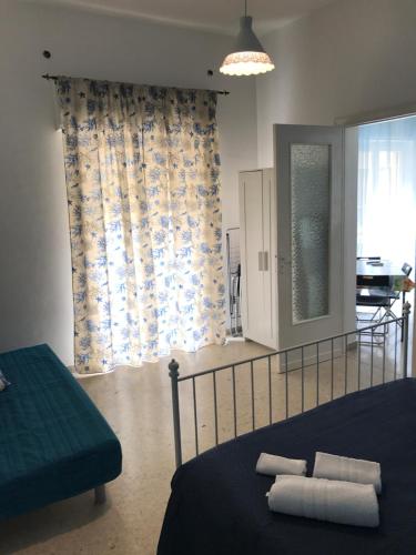 a bedroom with a bed with a blue blanket and a window at L'ANGOLO DI SAN MICHELE in Trapani