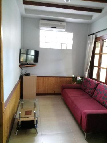 a living room with a red couch and a tv at Reuan Phaolai in Bophut 