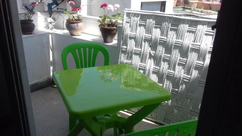 un tavolo verde e sedie sul balcone di Siwar a Rabat