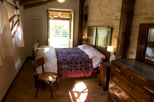 ein Schlafzimmer mit einem Bett, einer Kommode und einem Fenster in der Unterkunft Casa della Strega in Montegiorgio