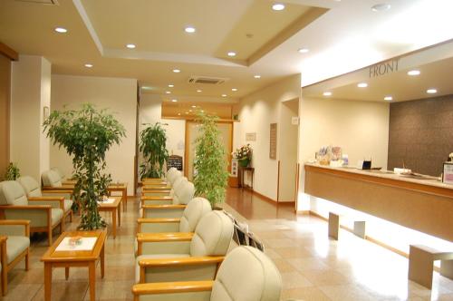 a lobby of a hospital with chairs and plants at Hotel Route-Inn Jouetsu in Joetsu