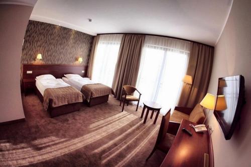 um quarto de hotel com uma cama e uma secretária em Hotel Pod Kluką em Słupsk