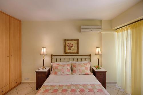 a bedroom with a bed with two night stands and two lamps at Antouanetta Apartments in Ermoupoli