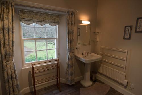 baño con lavabo y ventana en Elibank House B&B, en Walkerburn