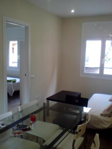 salon ze szklanym stołem i łóżkiem w obiekcie Castel Apartments w mieście Hospitalet de Llobregat