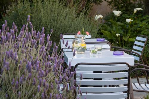 a table and chairs in a garden with flowers at Antouanetta Apartments in Ermoupoli