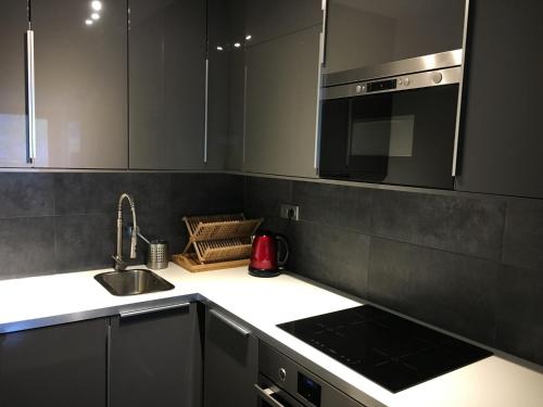 une cuisine avec un évier et un micro-ondes dans l'établissement Residence Du Brevent, à Chamonix-Mont-Blanc