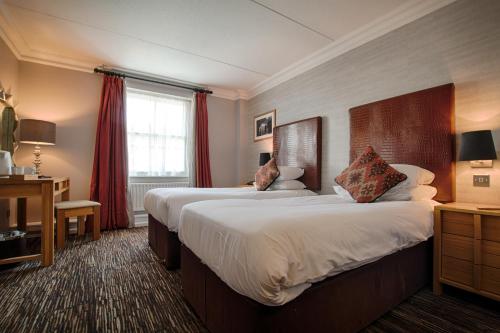 Postel nebo postele na pokoji v ubytování The Saracens Head Hotel