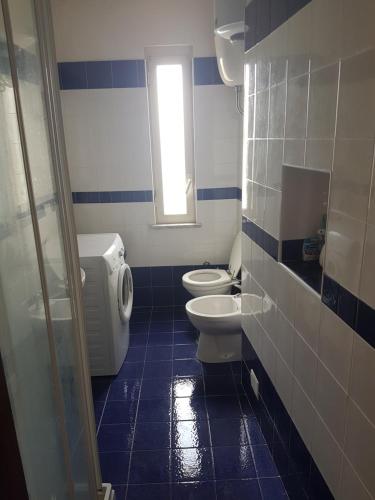 プローチダにあるCorricella Horizonの青と白のバスルーム(トイレ2つ、窓付)