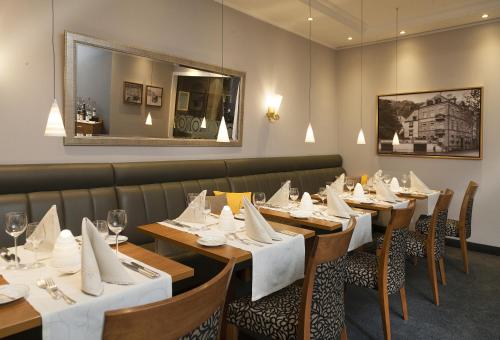 une salle à manger avec des tables en bois et un miroir dans l'établissement Boutique-Hotel Moseltor & Altstadt-Suiten, à Traben-Trarbach
