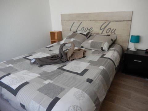 ein Bett mit einer Decke mit den Worten Liebe dich darauf in der Unterkunft Le Studio Sam in Illkirch-Graffenstaden