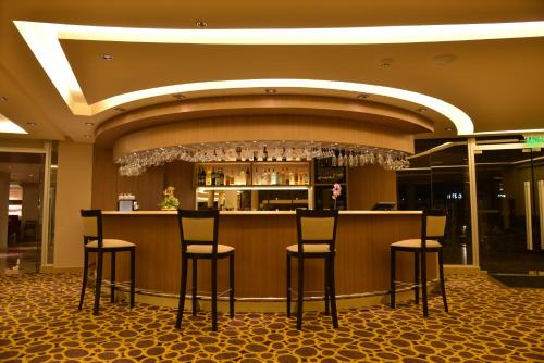 a bar in a hotel with stools in front of it at Falls Iguazú Hotel & Spa in Puerto Iguazú