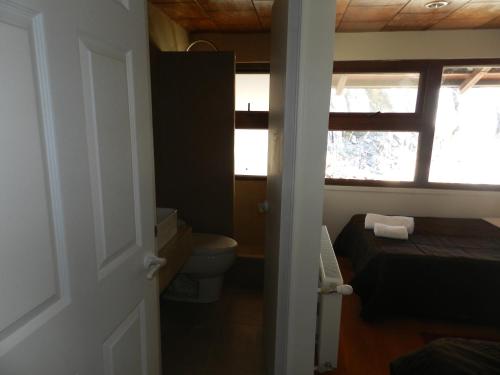 a small bathroom with a toilet and a window at Hotel HF in Farellones