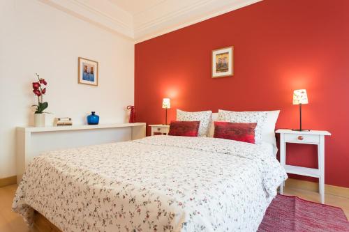 リスボンにあるTop Location Beautiful Apartmentの赤い壁のベッドルーム1室(大型ベッド1台付)