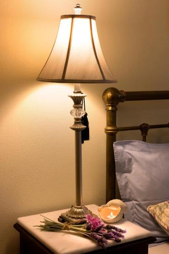 a lamp on a table next to a bed at Antouanetta Apartments in Ermoupoli
